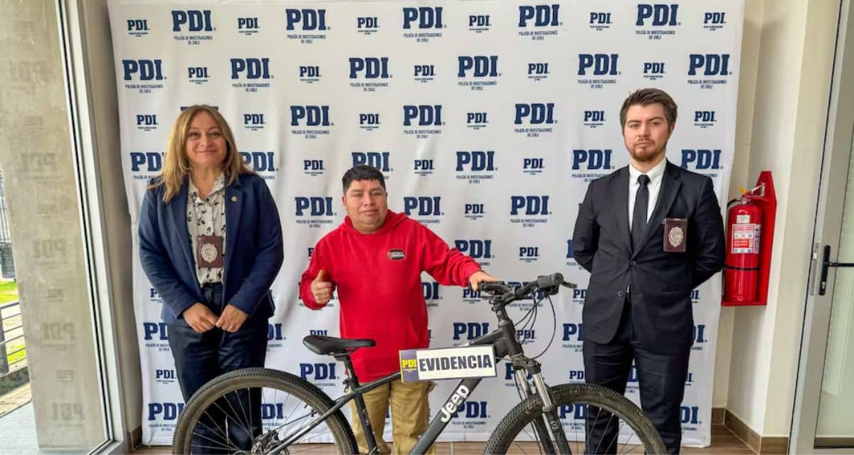 El influencer Carlitos Run y su mánager posando junto a su bicicleta marca Jeep en las dependencias del Complejo Policial de la PDI en Valdivia