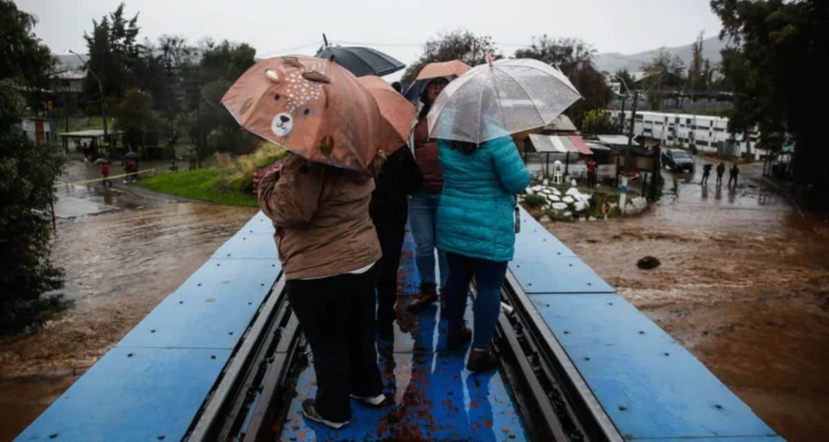 Personas protegiéndose de la intensa lluvia, graficando el complejo pronóstico del tiempo de mañana en la capital