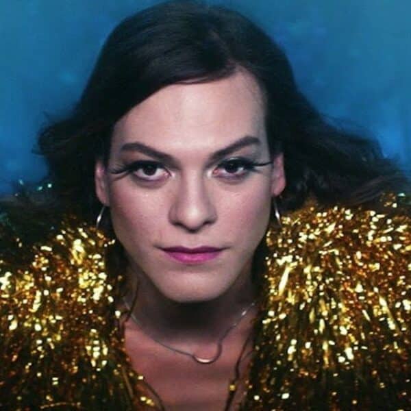 Daniela Vega posa con un vestido gris y botas rojas en una fotografía compartida desde Argentina