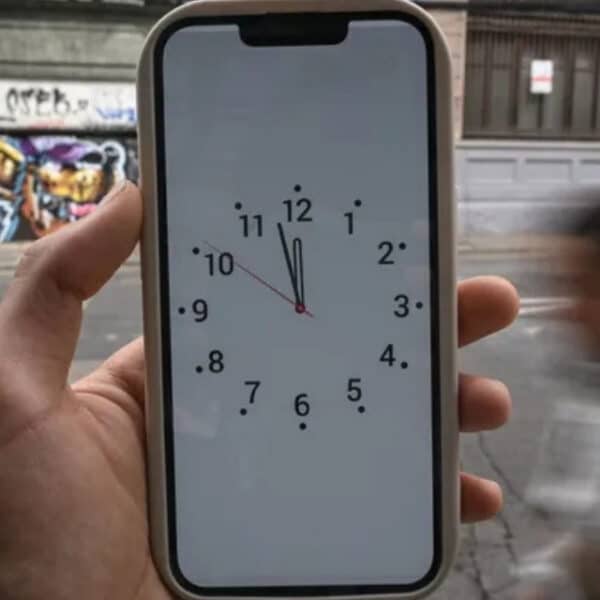 Reloj marcando el cambio de hora oficial en Chile junto a un mapa de husos horarios sudamericanos.