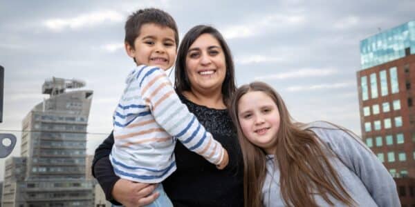 Madre junto a su hijo revisa en su celular la consulta del Bono de $30 mil por hijo en ChileAtiende
