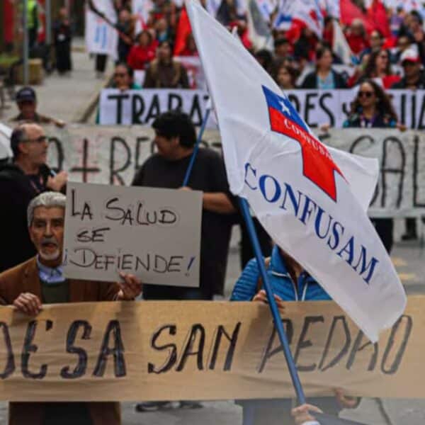 Funcionarios de la salud municipal marchando por las calles con pancartas y banderas gremiales, en alusión al paro nacional de 48 horas convocado por la Confusam en distintas ciudades del país para exigir un aumento en el financiamiento per cápita de la atención primaria, en medio del ingreso del Presupuesto 2027 al Congreso Nacional y con turnos éticos operativos para urgencias.