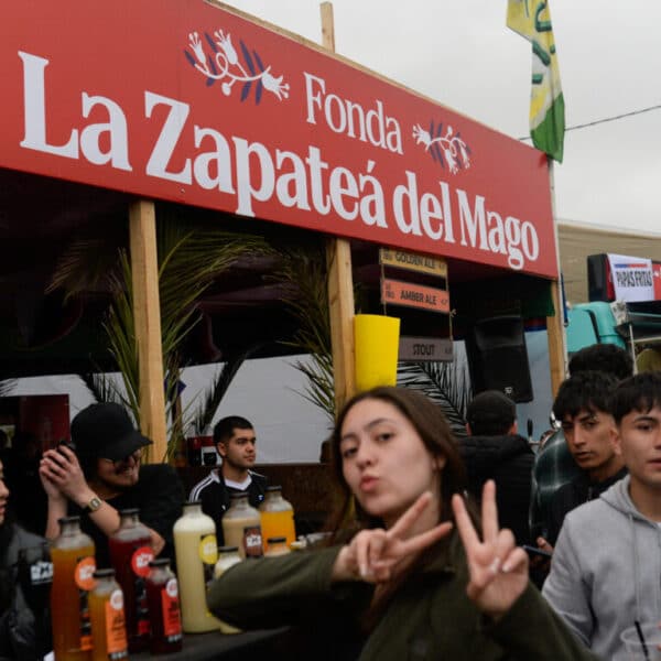 Letrero rojo de la fonda La Zapateá del Mago junto a asistentes en Fiestas Patrias 2026