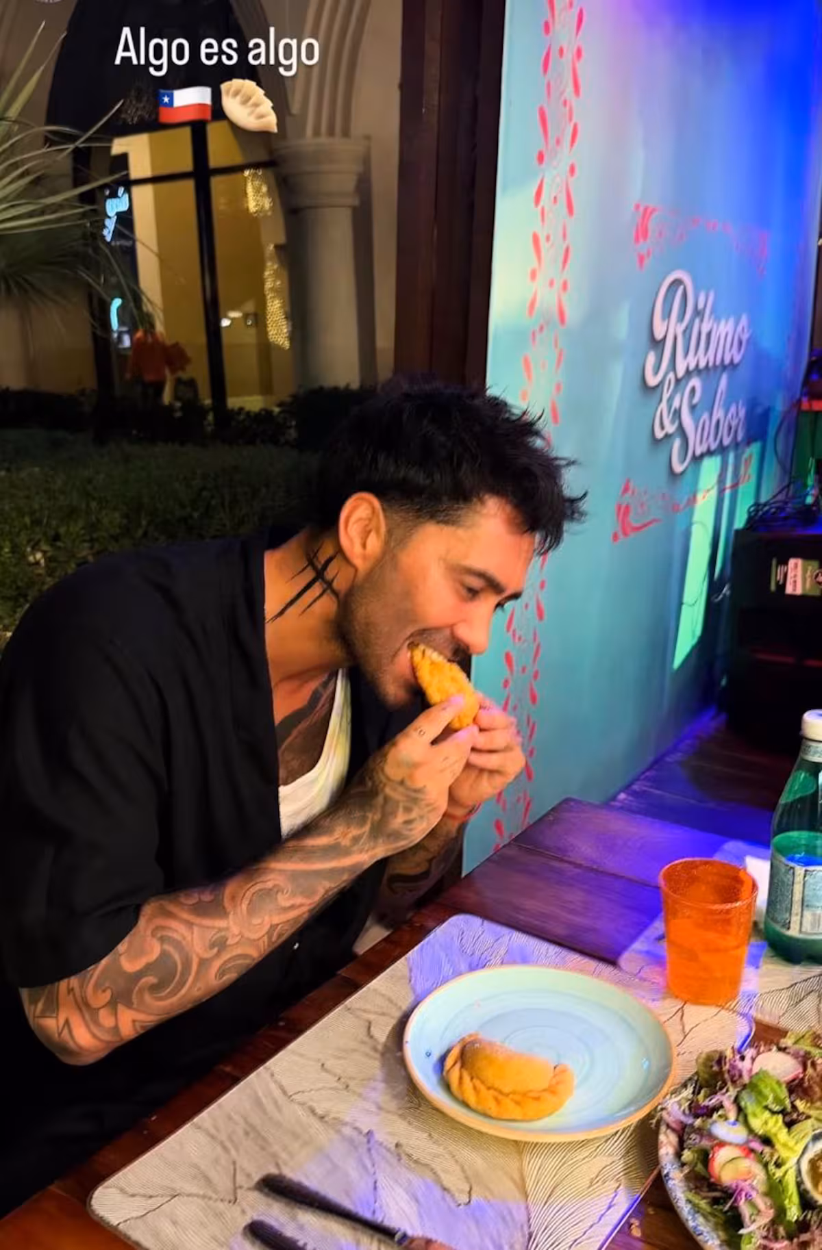 Luis Jiménez come una empanada en Fiestas Patrias mientras luce en su cuello tres cruces que cubren el tatuaje con el nombre de su exesposa.