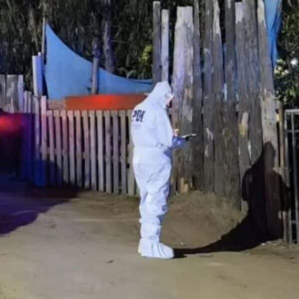 Detectives de la PDI y peritos de criminalística trabajando en un sitio acordonado, imagen referencial de la investigación por la muerte de una mujer de 60 años que fue encontrada sin vida en una tinaja de una parcela del sector Los Quillayes en Quilpué.