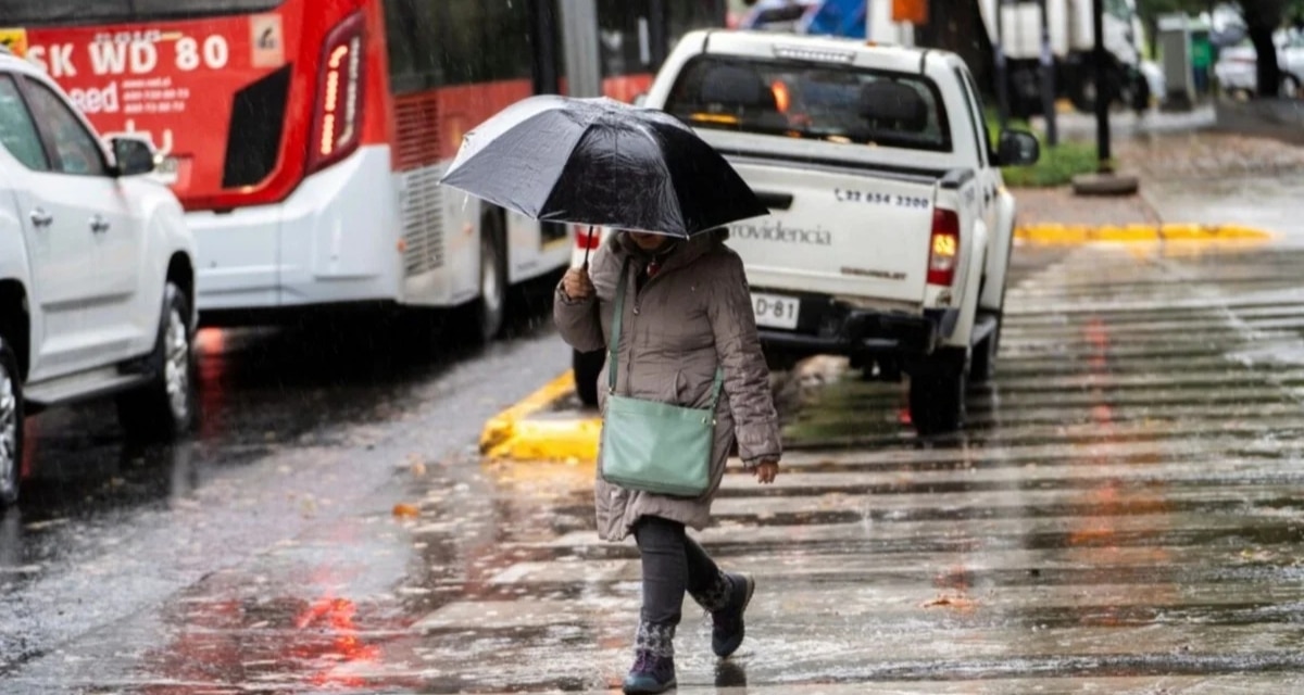 Persona con paraguas bajo intensa lluvia en el sur de Chile por el sistema frontal de inicio de septiembre