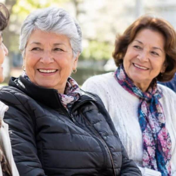 Mujer adulta mayor revisa documentos relacionados con su pensión, en el contexto de la Compensación por Expectativa de Vida.