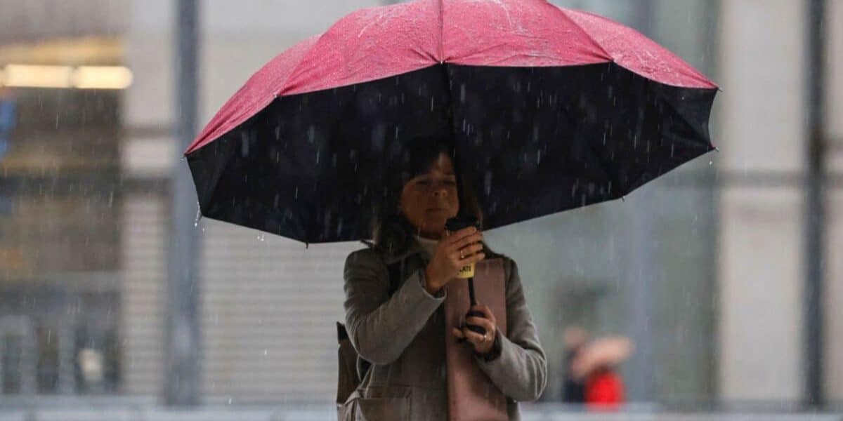 Personas con paraguas en una calle de Santiago durante una jornada de lluvia.