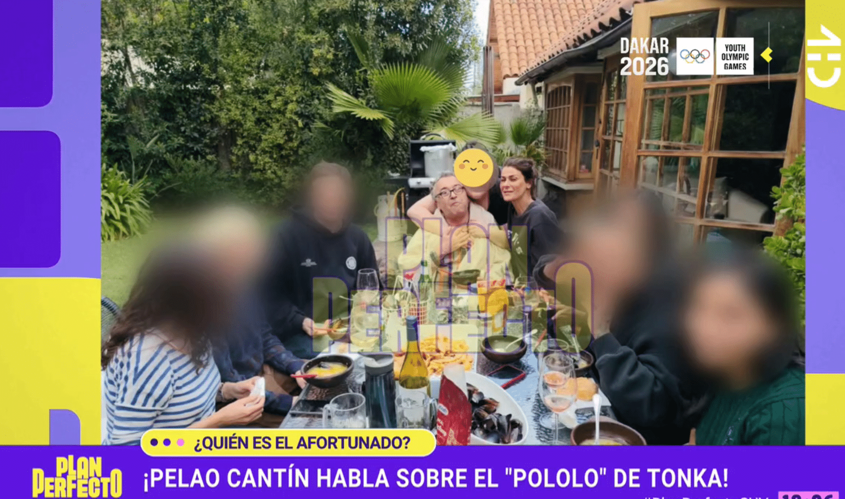 Varias personas están sentadas alrededor de una mesa con platos y copas en una terraza rodeada de plantas; algunos rostros aparecen difuminados. La imagen incluye gráficas televisivas.